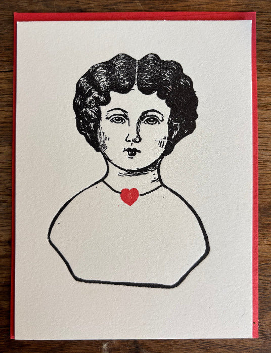 Illustration of a woman's face with a red heart on a white card with red envelop available at Littlecup
