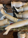 Collection of ceramic legs and feet displayed against a wooden background