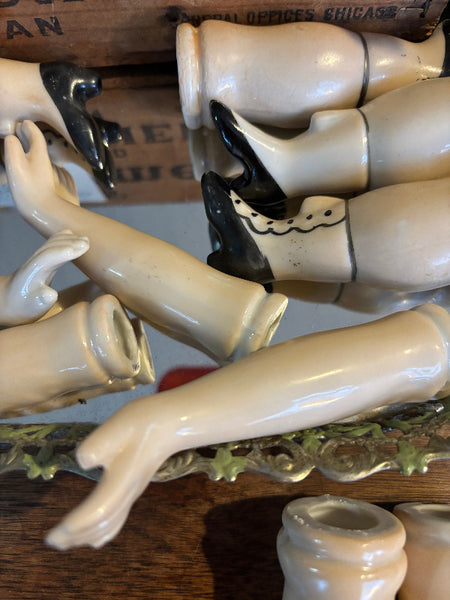Collection of ceramic legs and feet displayed against a wooden background