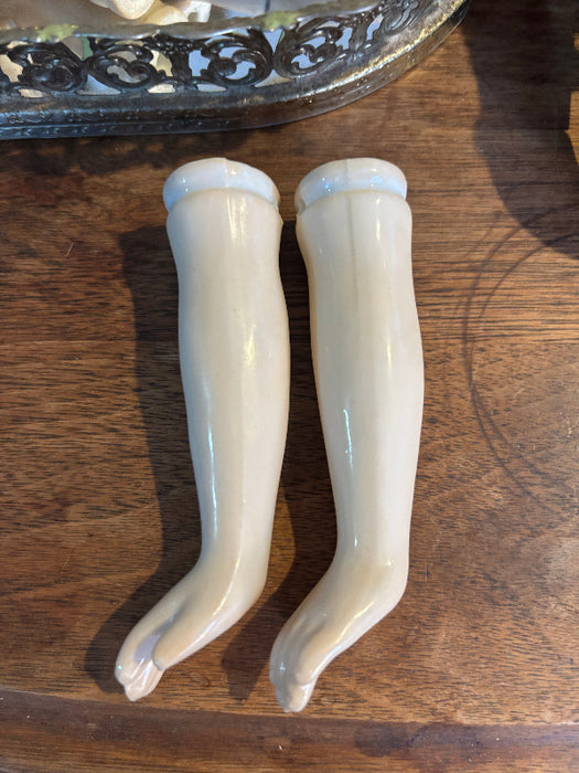 Two white ceramic handles on a wooden surface